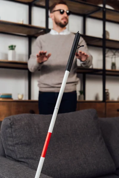 Selective focus of walking stick and blind man in living room — Stock Photo