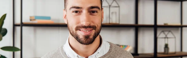 Panorâmica tiro de homem sorrindo para a câmera em casa — Fotografia de Stock