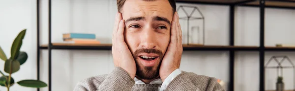 Worried man with hands beside face looking away, panoramic shot — Stock Photo