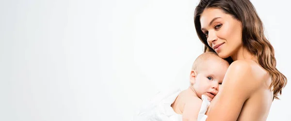 Plano panorámico de alegre madre desnuda abrazando al bebé, aislado en blanco - foto de stock