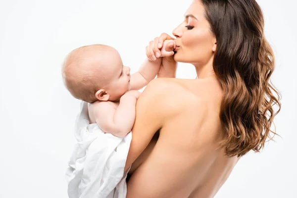Portrait de mère nue heureuse embrassant la main du bébé mignon, isolé sur blanc — Photo de stock