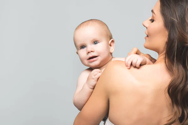 Porträt einer positiven nackten Mutter, die einen kleinen Jungen hält, isoliert auf grau — Stockfoto