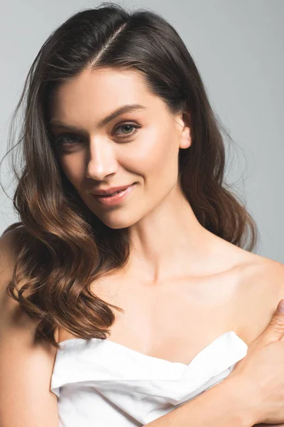 Smiling brunette woman with perfect skin, isolated on grey — Stock Photo