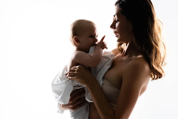 Silhouette der Mutter, die den kleinen Jungen auf Händen hält, isoliert auf weiß — Stockfoto