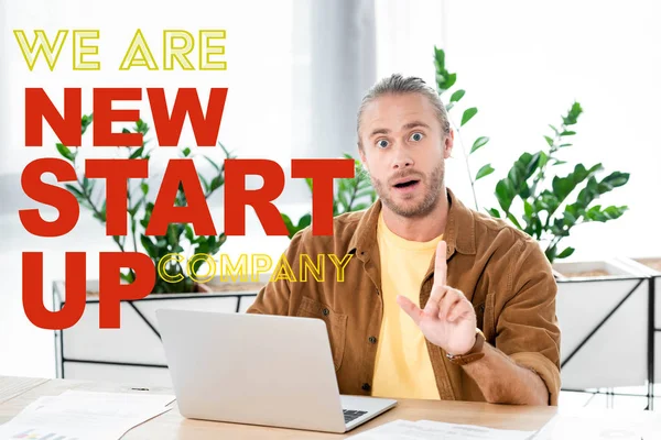 Handsome and shocked businessman showing idea sign in office with we are new startup company illustration — Stock Photo