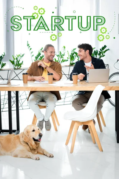Two handsome friends smiling and looking at each other with startup illustration above heads — Stock Photo