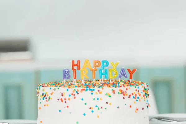Delicioso bolo de aniversário com velas coloridas e letras de aniversário feliz — Fotografia de Stock