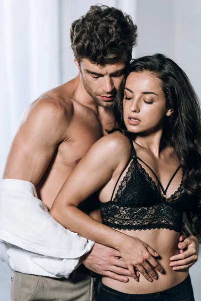 Sexy homem abraçando sexy namorada em preto rendas lingerie — Fotografia de Stock