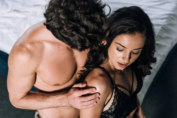 High angle view of sexy shirtless man embracing seductive girlfriend — Stock Photo