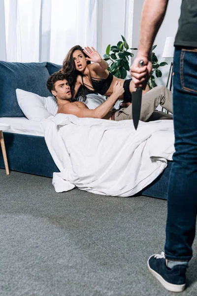 Shocked, scared woman showing stop gesture to husband holding knife — Stock Photo