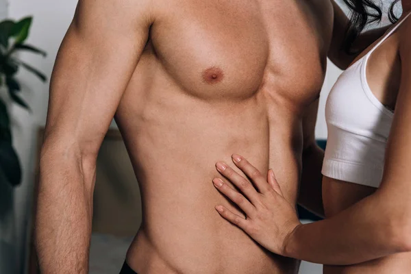 Cropped view of girl touching muscular torso of boyfriend — Stock Photo