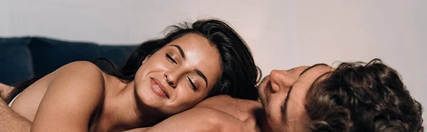 Panoramic shot of happy girl lying on chest of boyfriend — Stock Photo