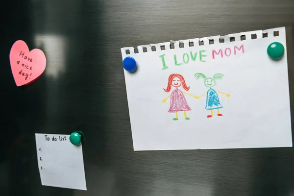 Close up view of notes and drawing on fridge door — Stock Photo