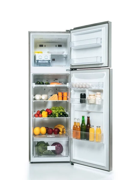 Open fridge and freezer with fresh food on shelves isolated on white — Stock Photo