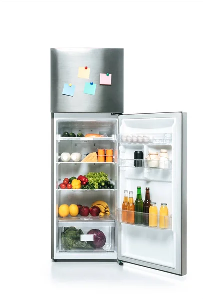 Offener Kühlschrank mit frischen Lebensmitteln in den Regalen und leeren, klebrigen Zetteln isoliert auf weiß — Stockfoto