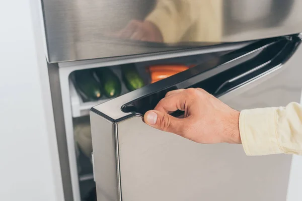 Обрізаний вид людини відкриті двері холодильника — стокове фото