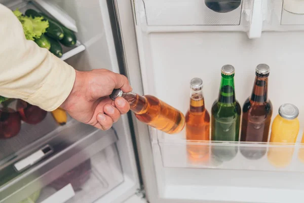 Ausgeschnittener Blick auf Mann, der Flasche Bier aus Kühlschrank holt — Stockfoto