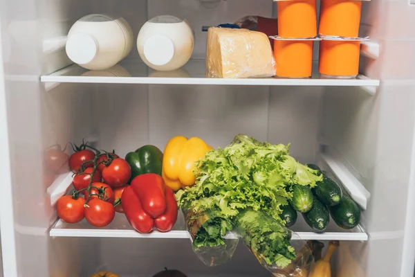 Offener Kühlschrank voller frischer Lebensmittel in den Regalen — Stockfoto