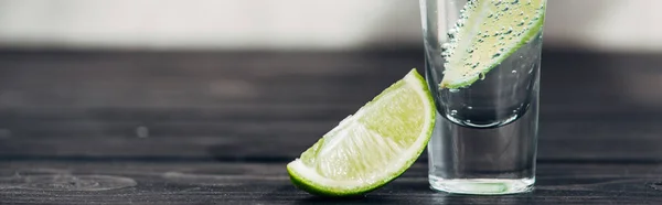 Tequila fraîche à la chaux sur surface bois, panoramique — Photo de stock