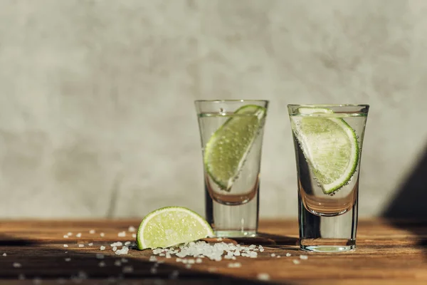 Frischer Tequila mit Limette und Salz auf Holzoberfläche im Sonnenlicht — Stockfoto