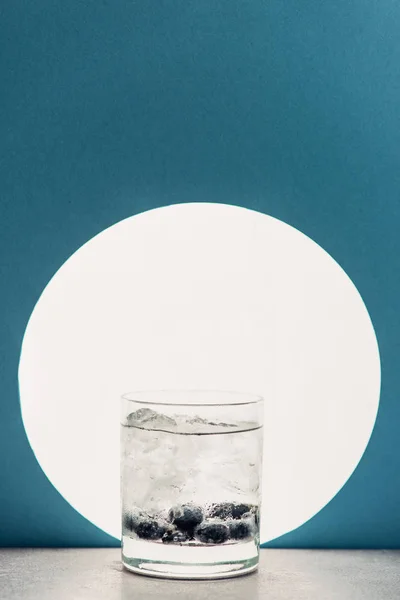 Frischer Gin Tonic im Glas auf blauem Hintergrund mit Gegenlicht — Stockfoto