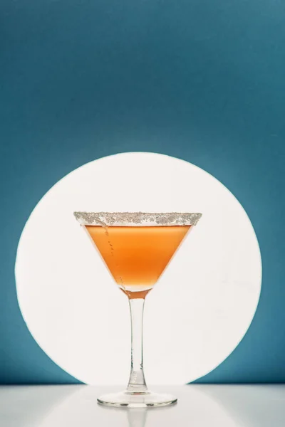 Fresh cocktail in martini glass on blue background with back light — Stock Photo