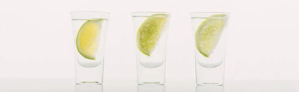 Tequila fraîche à la chaux en rangée isolée sur fond blanc, panoramique — Photo de stock