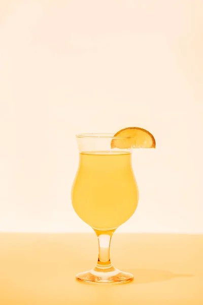 Yellow cocktail with citrus slice on bright background — Stock Photo