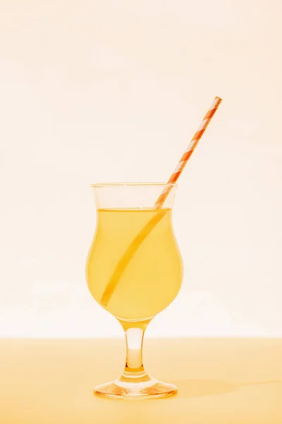 Yellow cocktail with straw on bright background — Stock Photo