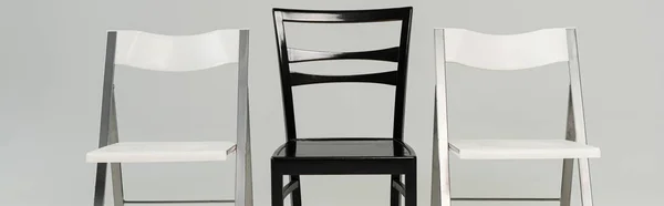 Black and white chairs isolated on grey, panoramic shot — Stock Photo