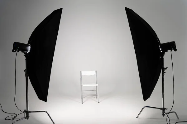 White chair with studio light on grey background — Stock Photo