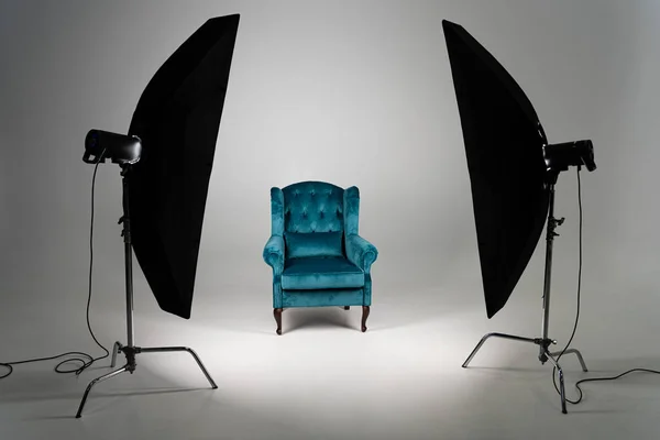 Blue armchair with studio light on grey background — Stock Photo