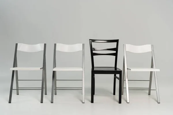 Empty black and white chairs on grey background — Stock Photo