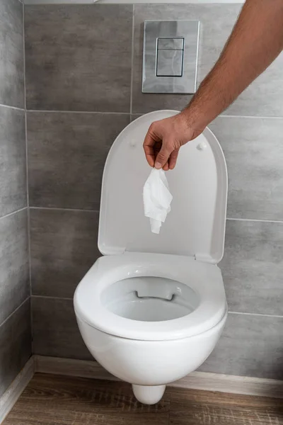 Vista cortada do homem segurando guardanapo acima vaso sanitário — Fotografia de Stock