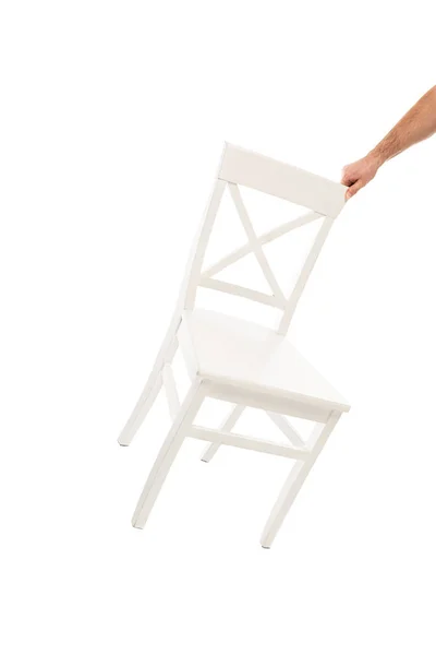 Vista recortada del hombre sosteniendo silla de madera blanca aislada en blanco - foto de stock