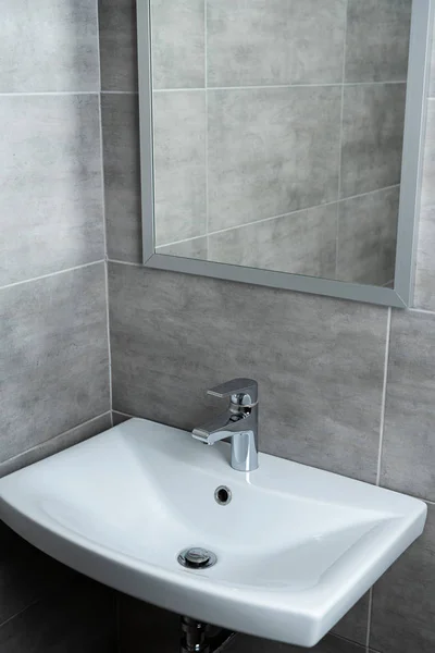 Ceramic washbasin with mirror in modern washroom with grey tile — Stock Photo