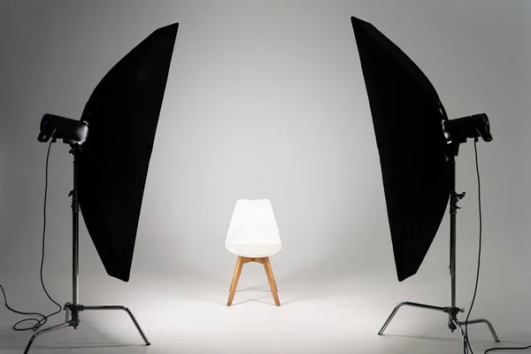 Chaise moderne blanche avec lumière de studio sur fond gris — Photo de stock