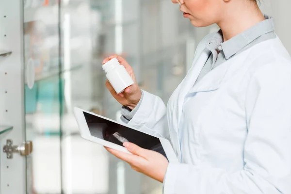 Vista cortada do frasco de retenção farmacêutico com pílulas e tablet digital na farmácia — Fotografia de Stock