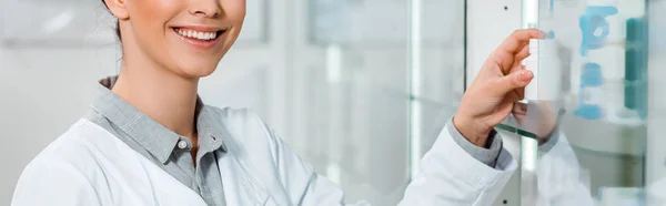 Vista ritagliata del farmacista sorridente dalla vetrina, colpo panoramico — Stock Photo