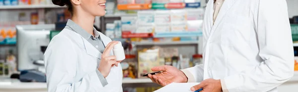 Vista ritagliata di farmacisti con appunti e pillole in farmacia — Foto stock