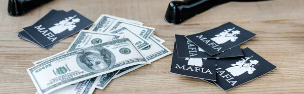 KYIV, UCRAINA - 22 NOVEMBRE 2019: colpo panoramico di banconote da un dollaro vicino a carte da gioco con lettere mafiose e maschere da festa sul tavolo — Foto stock