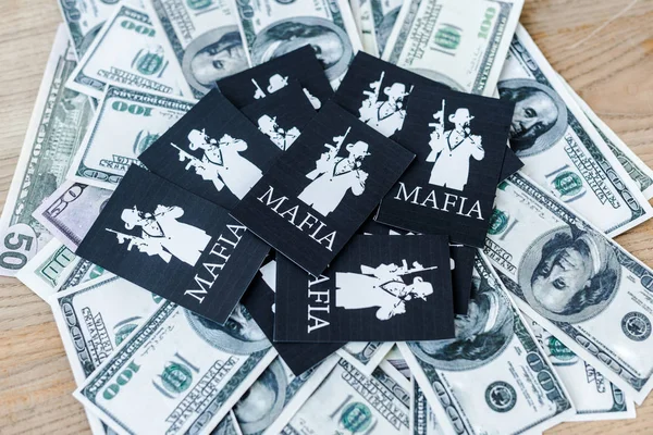 KYIV, UKRAINE - 22 NOVEMBRE 2019 : vue du dessus des billets en dollars près des cartes à jouer avec des lettres mafieuses — Photo de stock