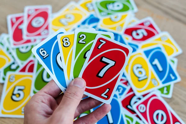 KYIV, UKRAINE - NOVEMBER 22, 2019: cropped view of man holding colorful uno playing cards — Stock Photo