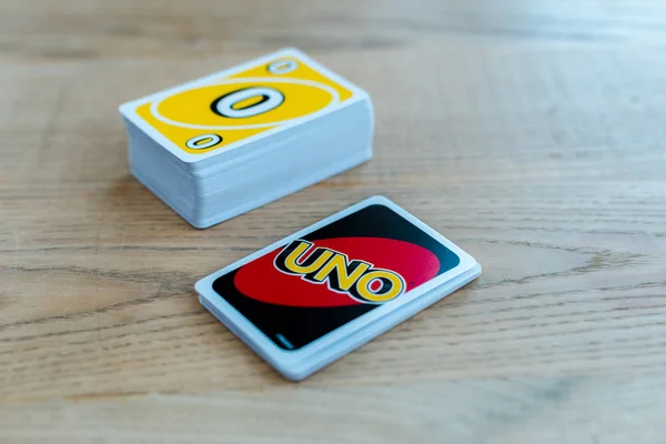 KYIV, UKRAINE - NOVEMBER 22, 2019: selective focus of uno letters on playing card near stack on wooden table — Stock Photo