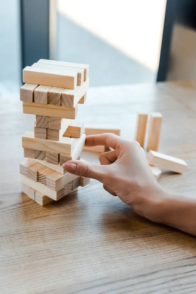 QUIIV, UCRÂNIA - NOVEMBRO 22, 2019: visão recortada de mulher jogando blocos de jogo de torre de madeira em casa — Fotografia de Stock