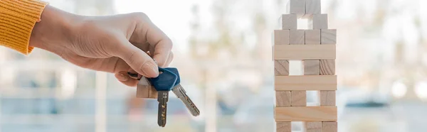 KYIV, UKRAINE - NOVEMBER 22, 2019: panoramic shot of woman holding keys blocks wood tower game — Stock Photo