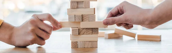 KYIV, UKRAINE - NOVEMBER 22, 2019: panoramic shot of women playing blocks wood tower game at home — Stock Photo