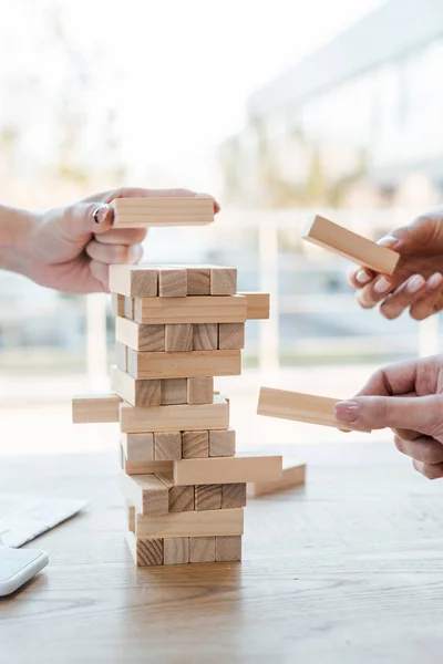 KYIV, UKRAINE - NOVEMBER 22, 2019: cropped view of women playing blocks wood tower game — Stock Photo