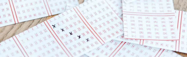 Tiro panorâmico de bilhetes de loteria marcados na mesa de madeira — Fotografia de Stock