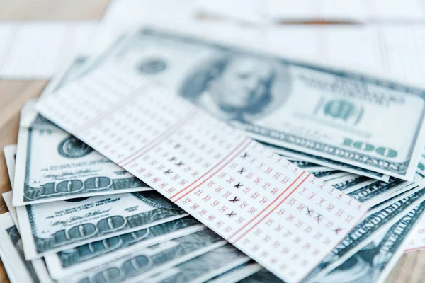 Selective focus of marked lottery ticket near dollar banknotes on table — Stock Photo